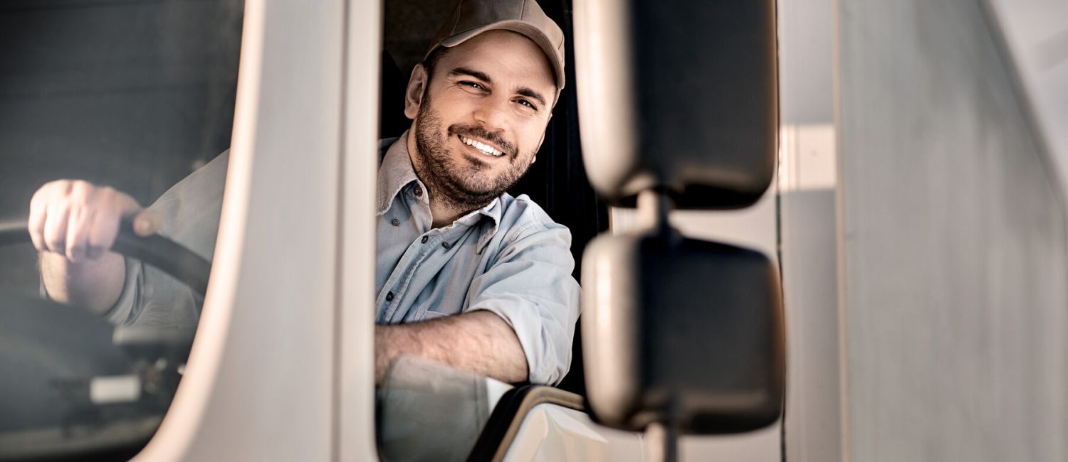 Symbolic image of a lorry driver smiling from his cab